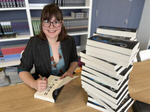 Author signing book copies up close